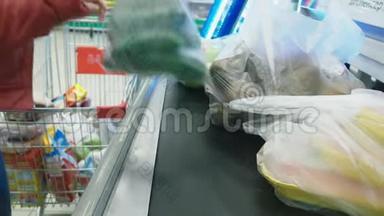 现金在超市，一个女人在超市的结账处买杂货。 4k，特写